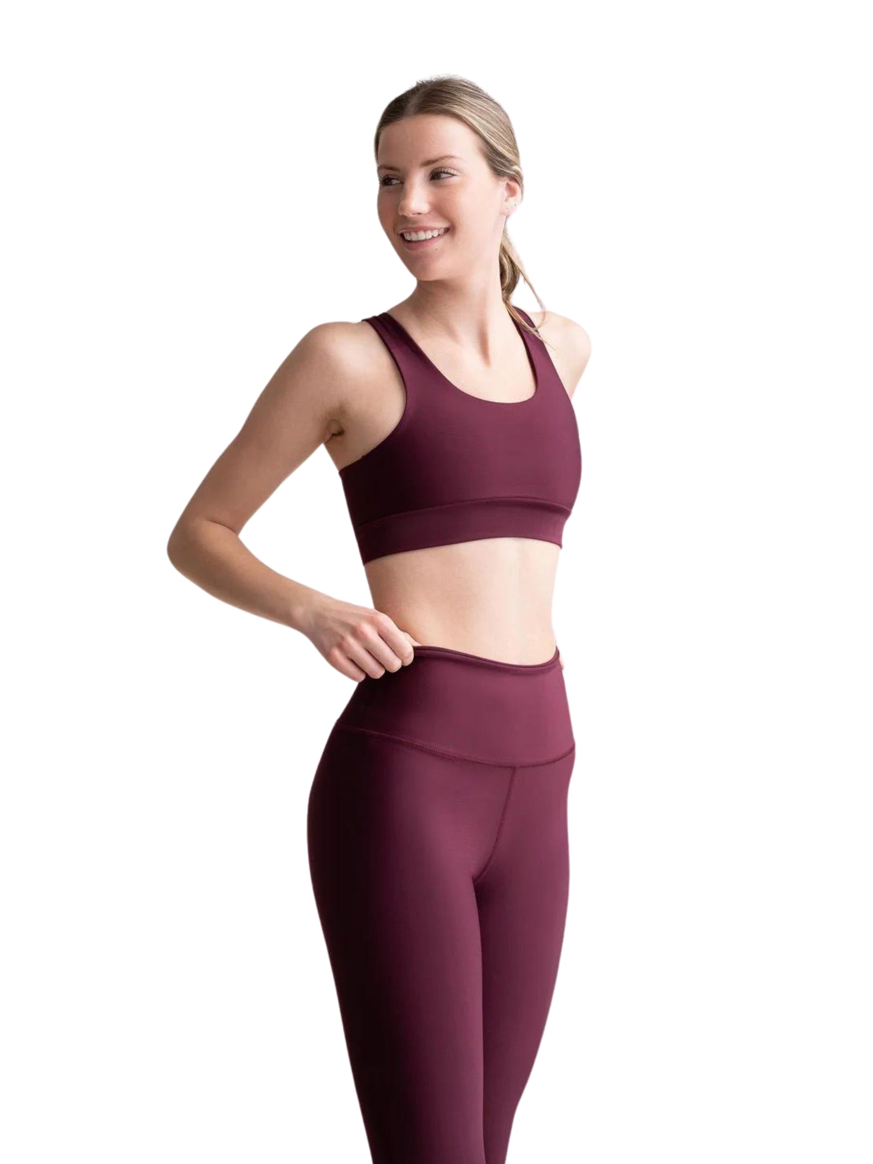 Person in Lisminas 4312 Capri-Leggings in Bordeaux, hohe Taille, lächelnd und nach rechts blickend vor einem weißen Hintergrund.